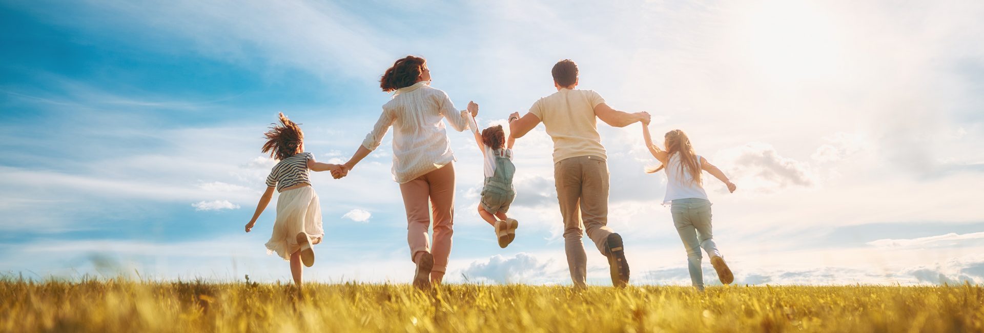 Happy family on summer walk! Mother, father and daughters walking in the Park and enjoying the beautiful nature.